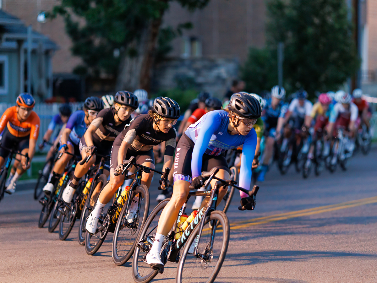 Cyclists in the Audi Denver Littleton Twilight Criterium round a corner on a sunny day.